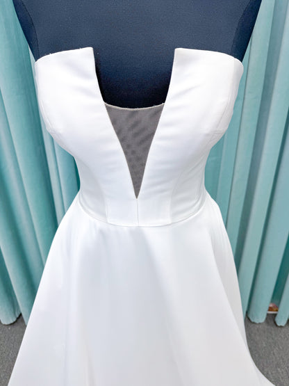 Light Mikado A-line wedding dress with strapless bodice, plunging V-neckline, illusion inset, defined waist, and full skirt.