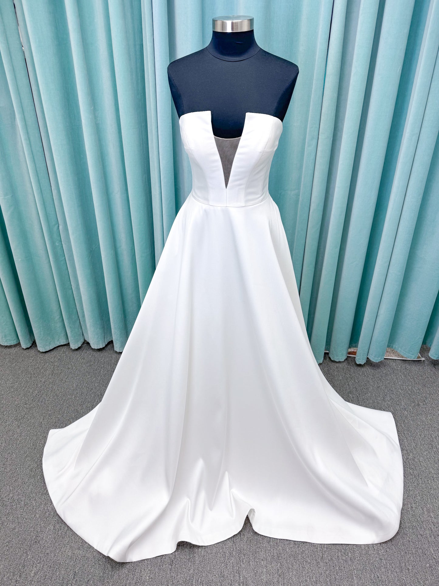 Light Mikado A-line wedding dress with strapless bodice, plunging V-neckline, illusion inset, defined waist, and full skirt.