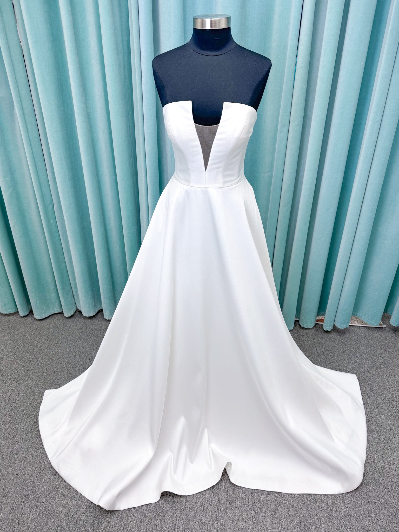 Light Mikado A-line wedding dress with strapless bodice, plunging V-neckline, illusion inset, defined waist, and full skirt.