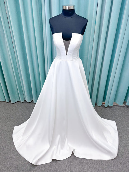 Light Mikado A-line wedding dress with strapless bodice, plunging V-neckline, illusion inset, defined waist, and full skirt.