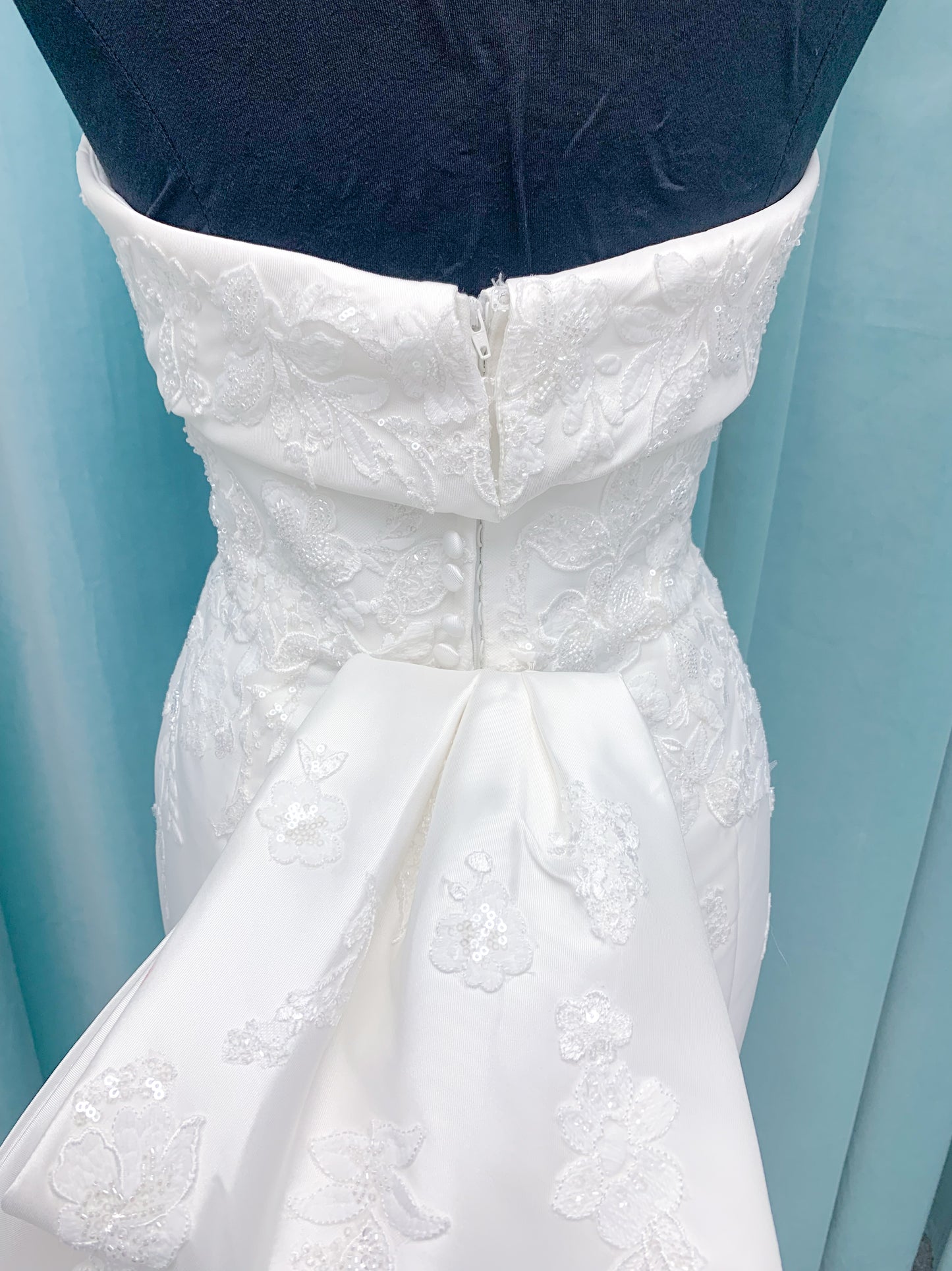 Morilee 2905 Atalanta fit and flare wedding dress in stretch Mikado with fold-over strapless neck, beaded lace bodice, and detachable double-loop embellished bow.