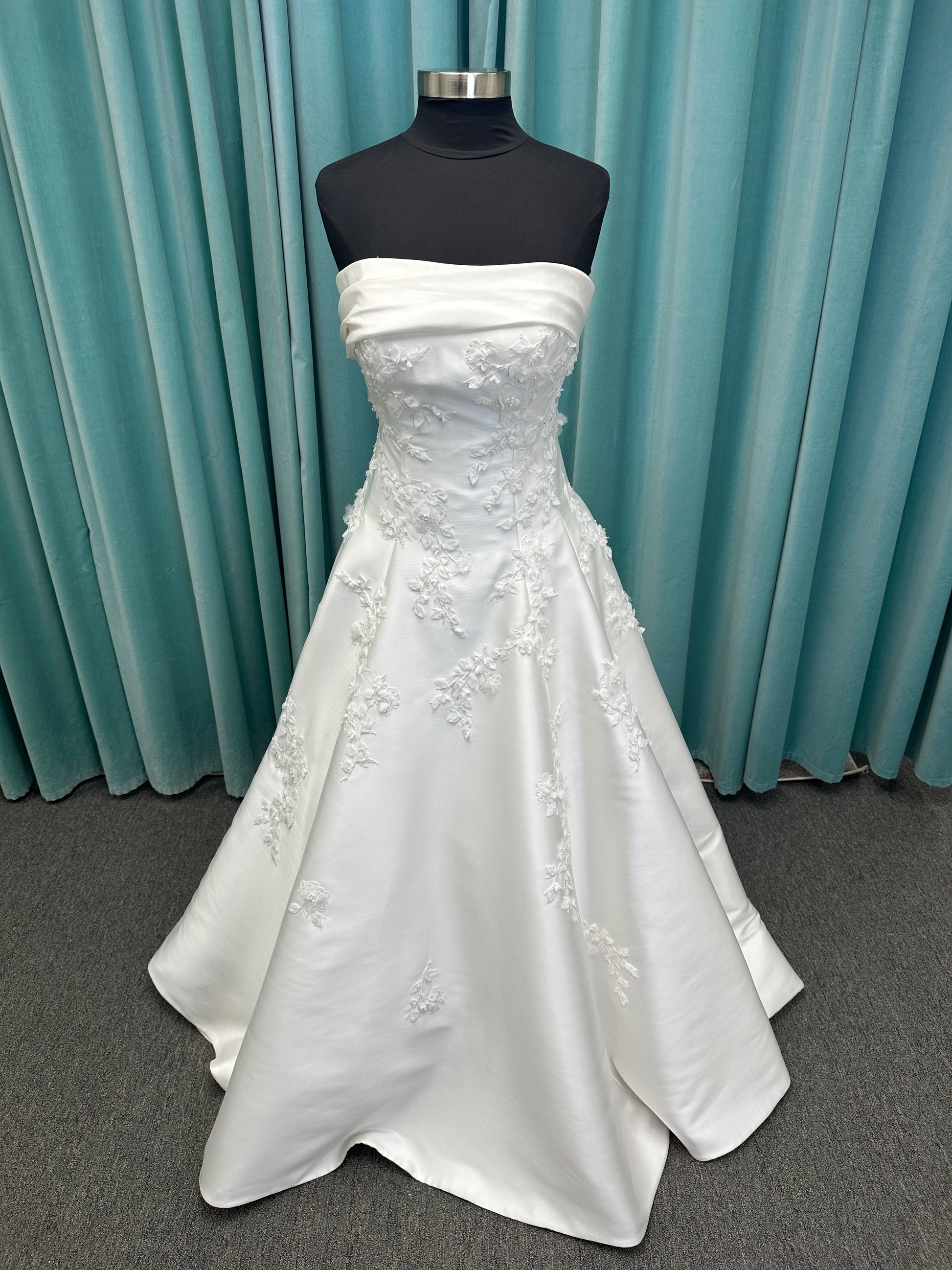 Essense of Australia D4195 ivory lace and Mikado drop-waist wedding dress on mannequin with strapless square neckline, 3D appliqué bodice, and A-line skirt.
