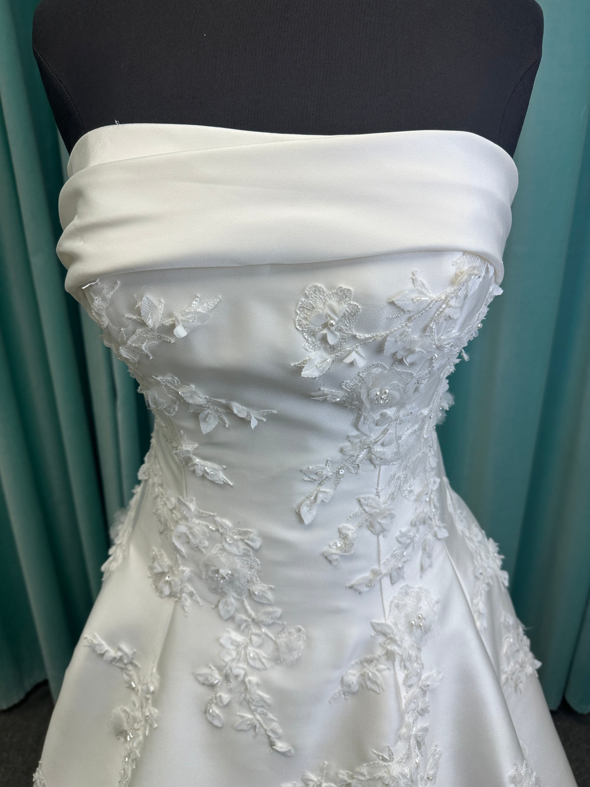 Essense of Australia D4195 ivory lace and Mikado drop-waist wedding dress on mannequin with strapless square neckline, 3D appliqué bodice, and A-line skirt.
