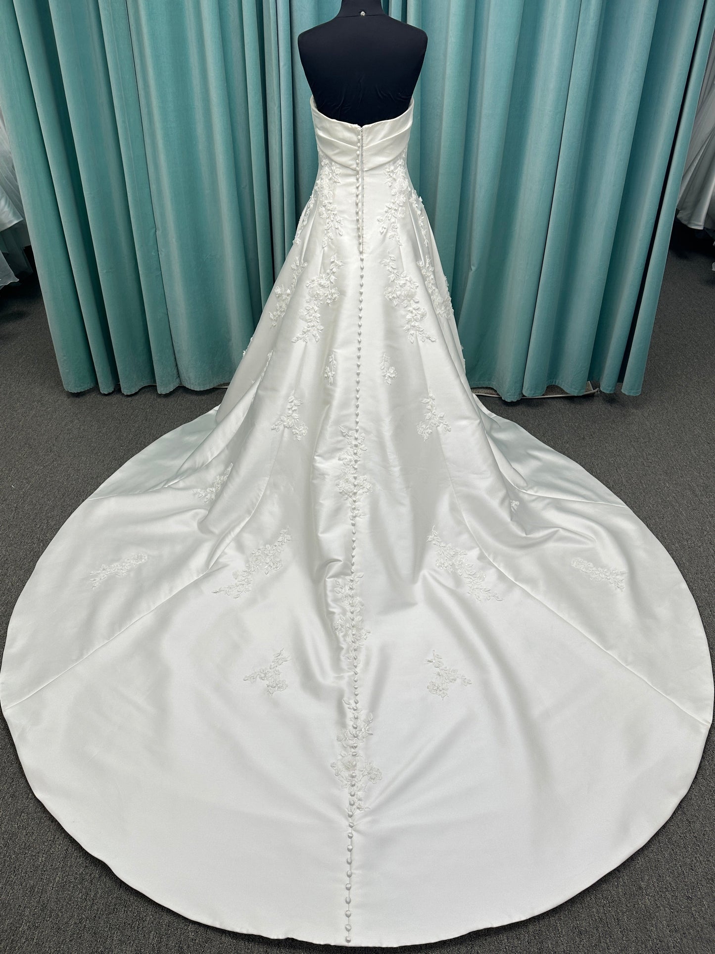 Essense of Australia D4195 ivory lace and Mikado drop-waist wedding dress on mannequin with strapless square neckline, 3D appliqué bodice, and A-line skirt.
