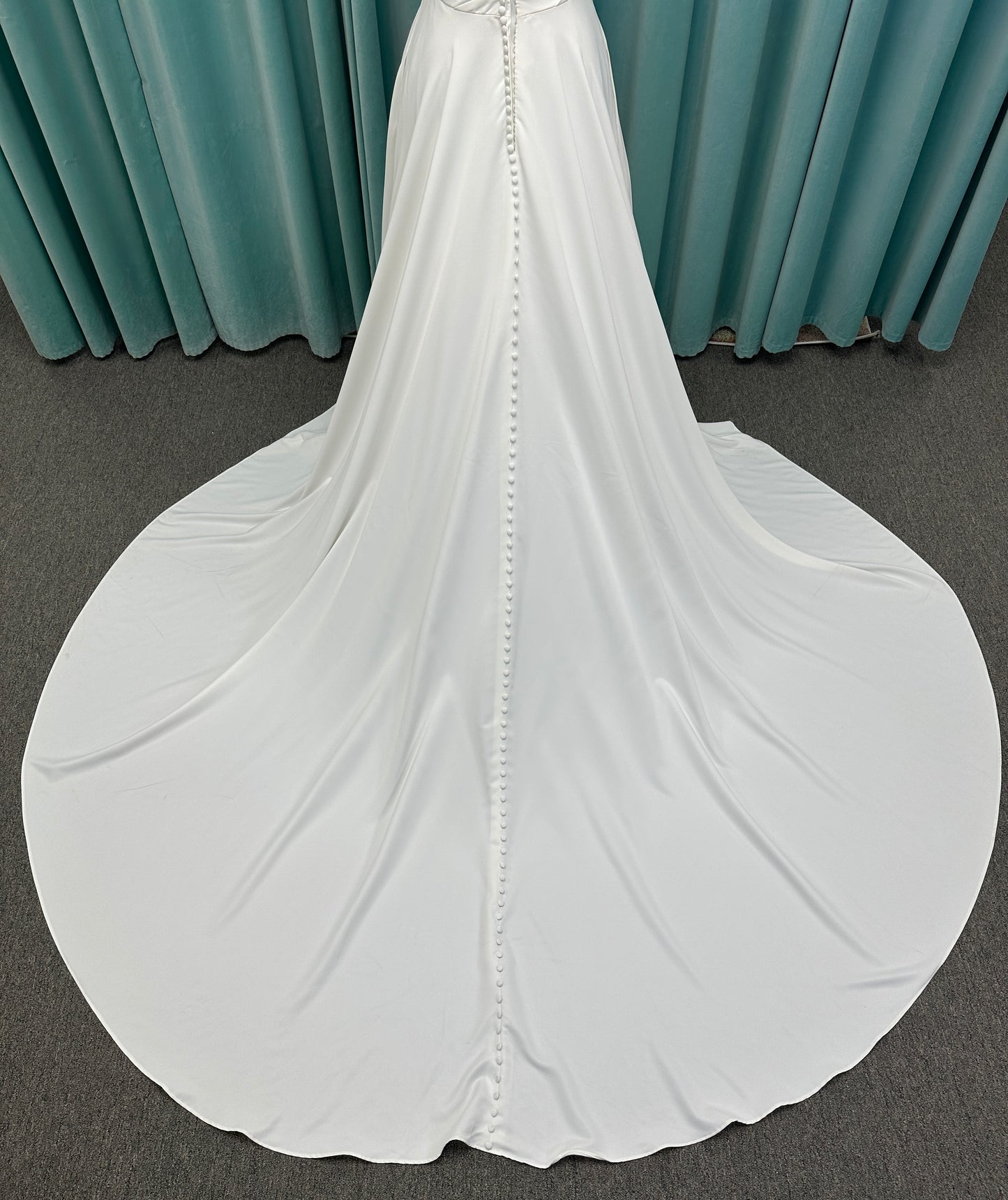 Essense of Australia D4225 ivory satin A-line wedding dress on mannequin with strapless scoop neckline, ruched bodice, and a front slit in the skirt.
