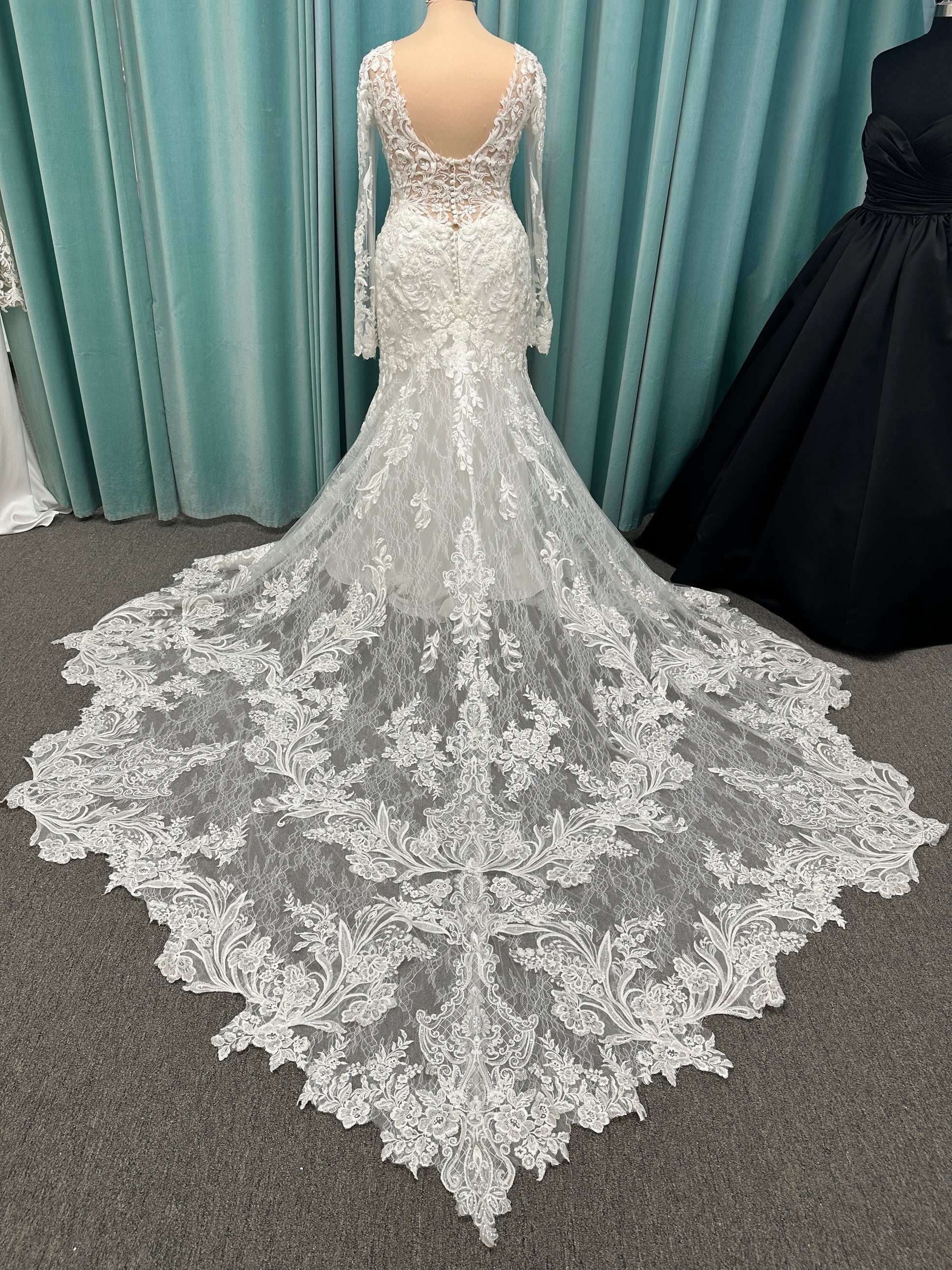 Essense of Australia D4213 lace fit-and-flare wedding dress with plunging neckline and sheer lace sleeves featuring a long lace train