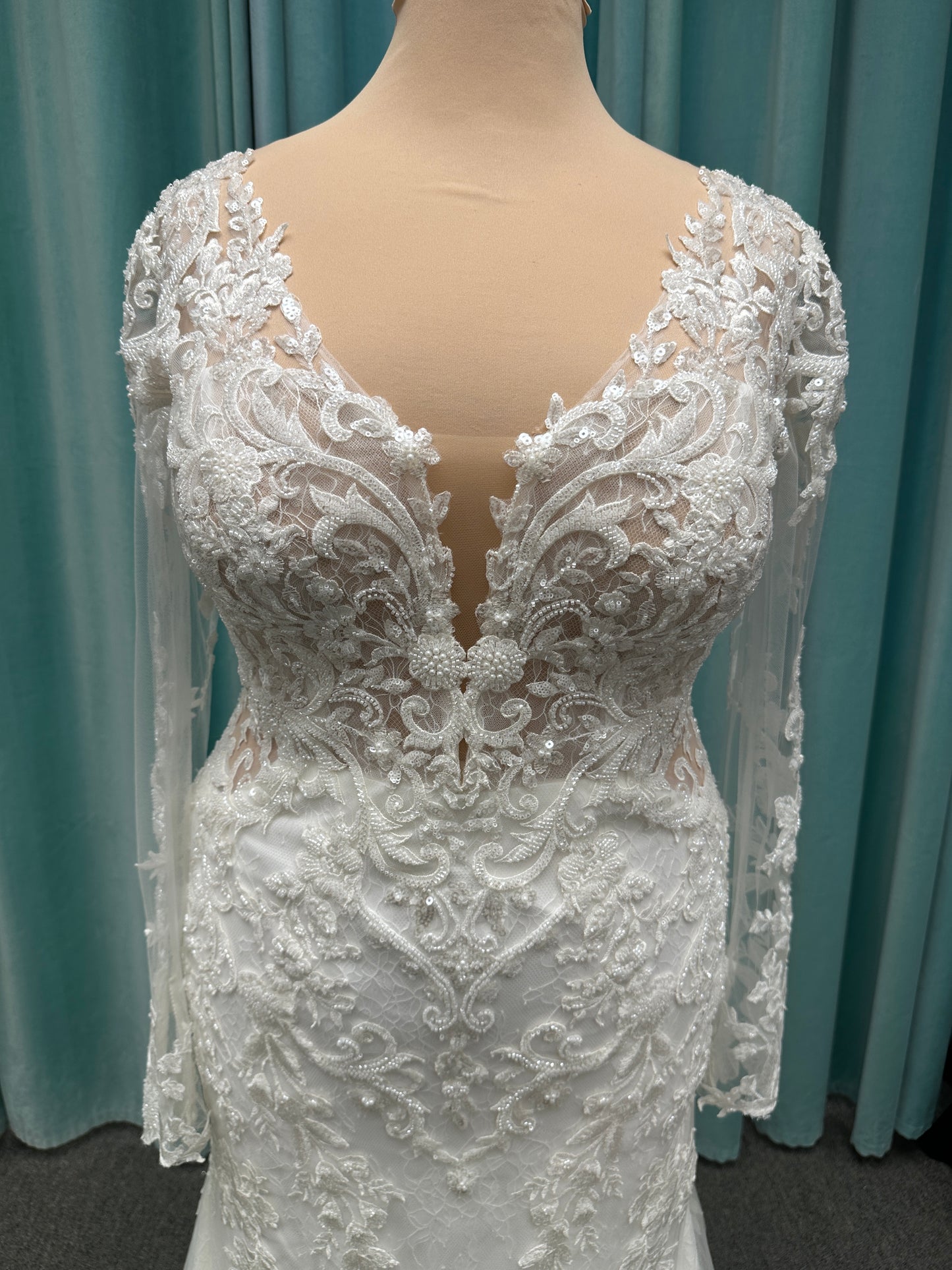 Essense of Australia D4213 lace fit-and-flare wedding dress with plunging neckline and sheer lace sleeves featuring a long lace train