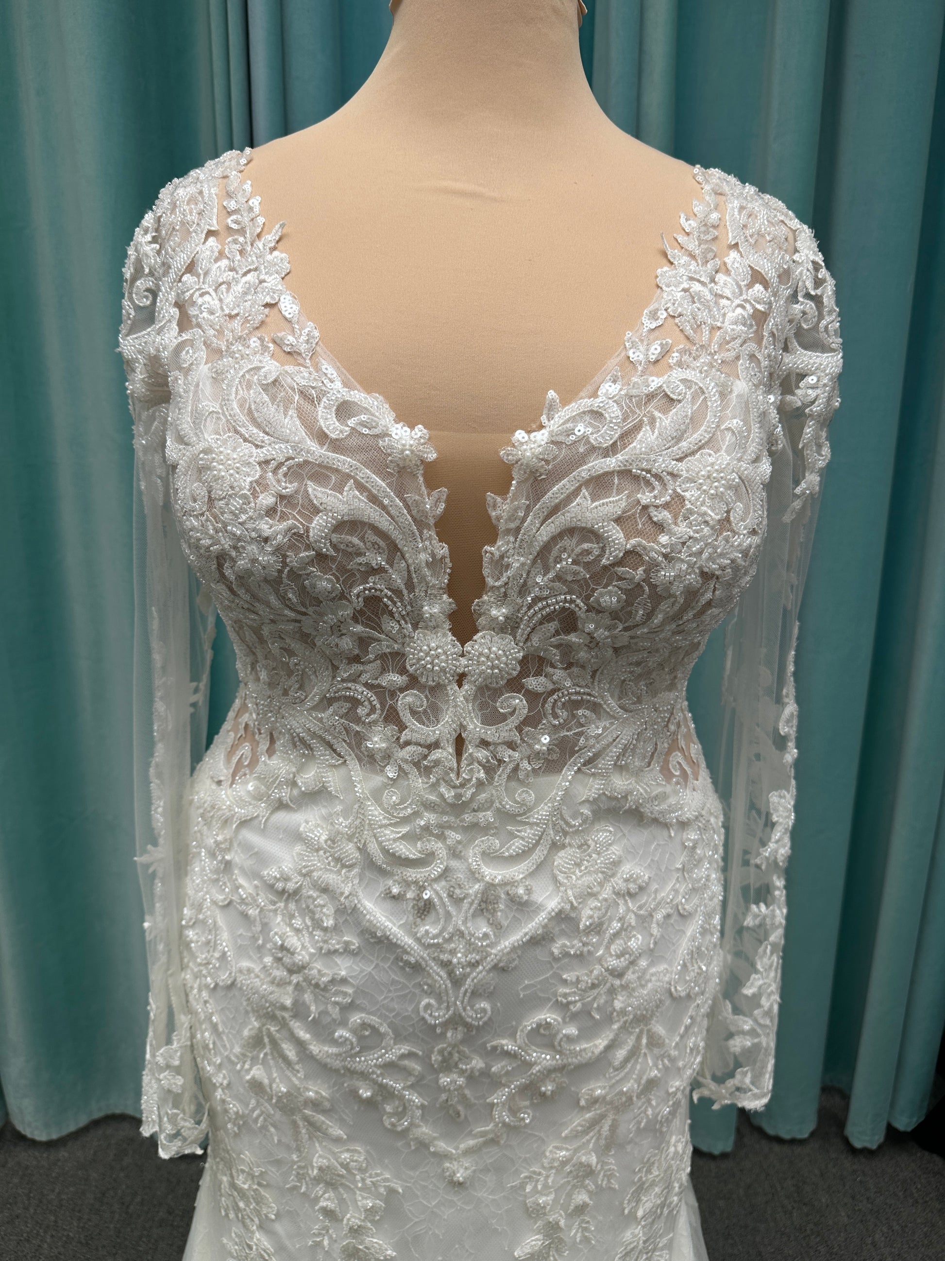 Essense of Australia D4213 lace fit-and-flare wedding dress with plunging neckline and sheer lace sleeves featuring a long lace train