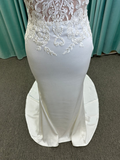 Calliope ivory spaghetti strap V-neck fit-and-flare wedding dress on mannequin with 3D floral lace appliqué bodice and sleek crepe skirt.
