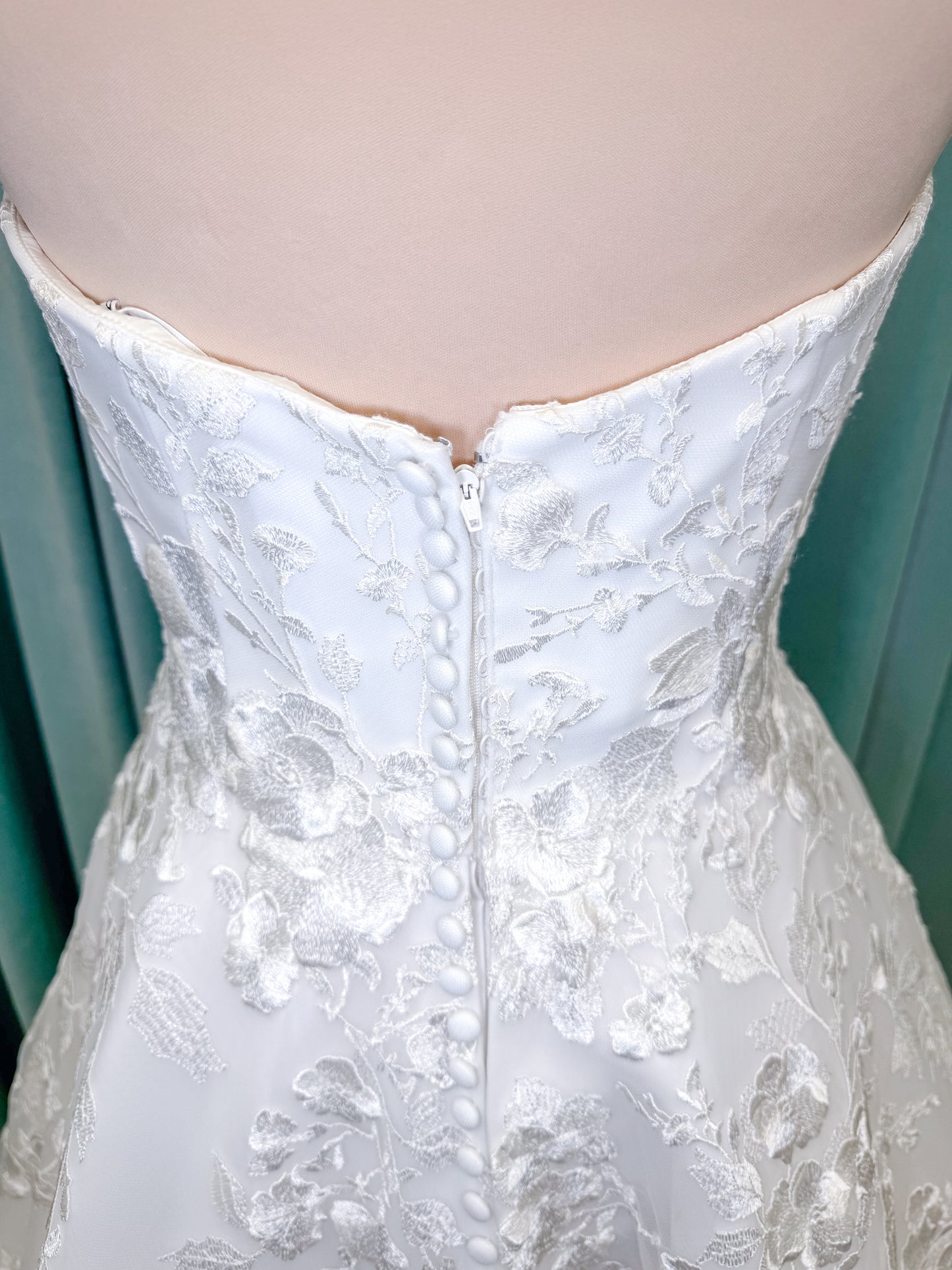 Morilee 2987 Callyso A-line wedding dress on mannequin with strapless tulle, floral threadwork, detachable puff sleeves, and flowing train