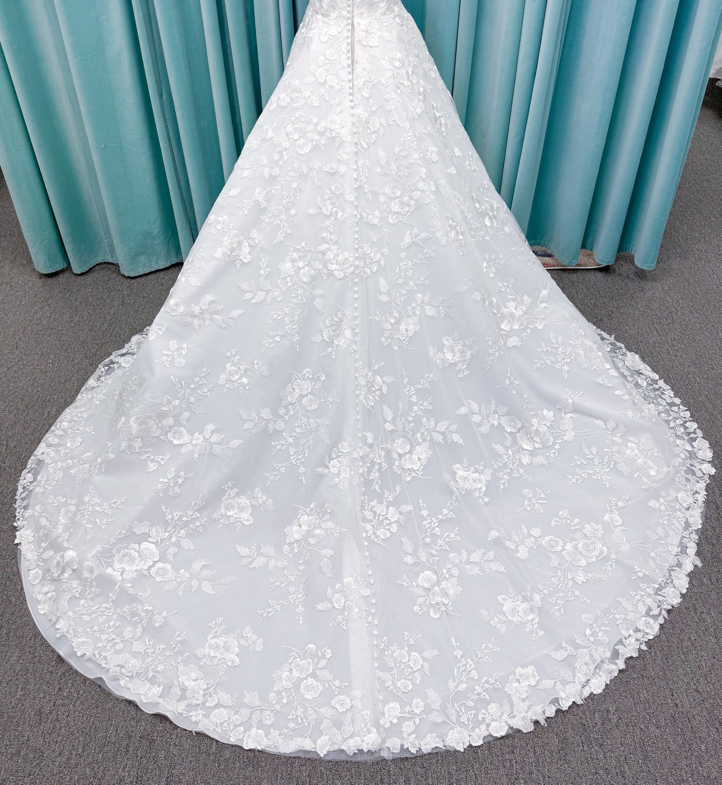 Morilee 2987 Callyso A-line wedding dress on mannequin with strapless tulle, floral threadwork, detachable puff sleeves, and flowing train