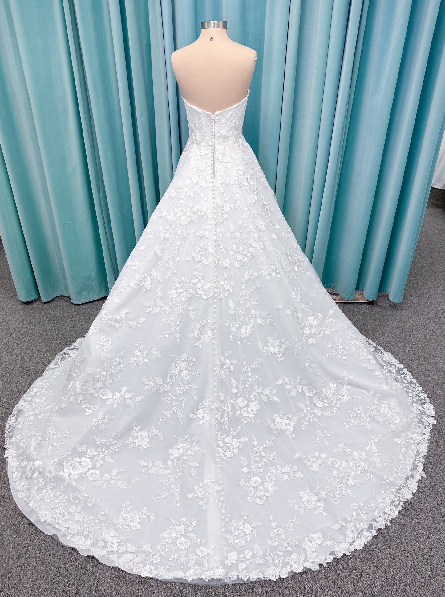 Morilee 2987 Callyso A-line wedding dress on mannequin with strapless tulle, floral threadwork, detachable puff sleeves, and flowing train