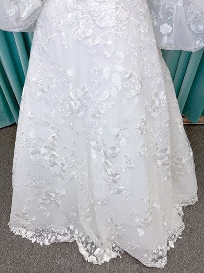 Morilee 2987 Callyso A-line wedding dress on mannequin with strapless tulle, floral threadwork, detachable puff sleeves, and flowing train