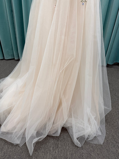 Stella York 8063 ivory and pastel colorful embroidered lace A-line wedding dress on mannequin with floral spaghetti straps, scoop neckline, and soft tulle skirt.

