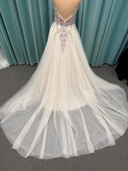 Stella York 8063 ivory and pastel colorful embroidered lace A-line wedding dress on mannequin with floral spaghetti straps, scoop neckline, and soft tulle skirt.
