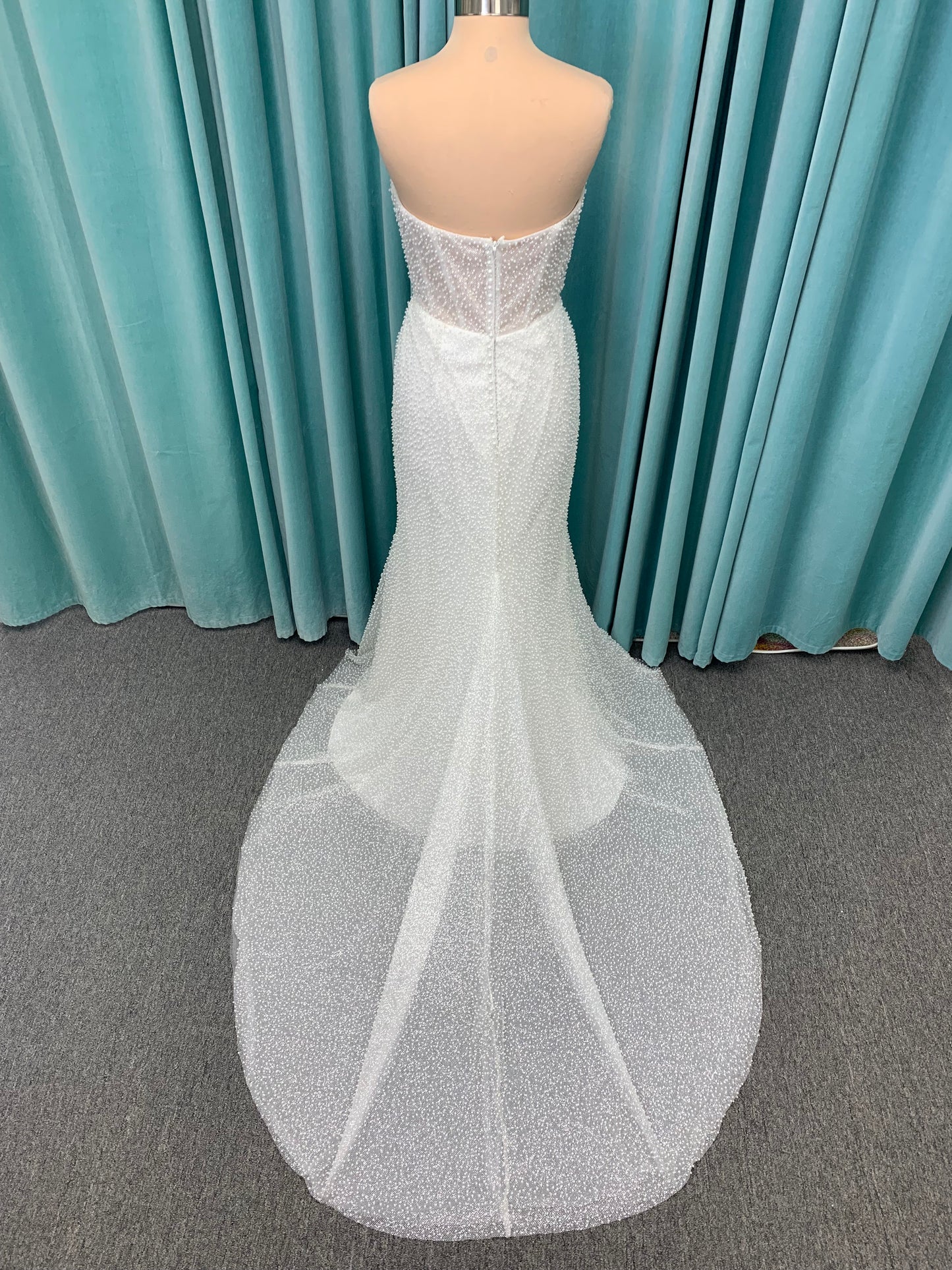 Cynthia ivory strapless fit-and-flare wedding dress on mannequin with pearl-beaded corset bodice and sweetheart neckline.
