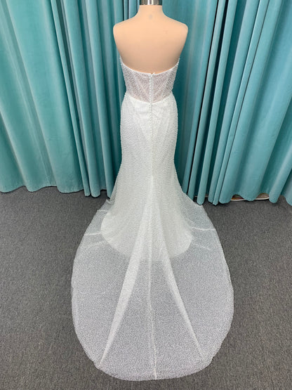 Cynthia ivory strapless fit-and-flare wedding dress on mannequin with pearl-beaded corset bodice and sweetheart neckline.
