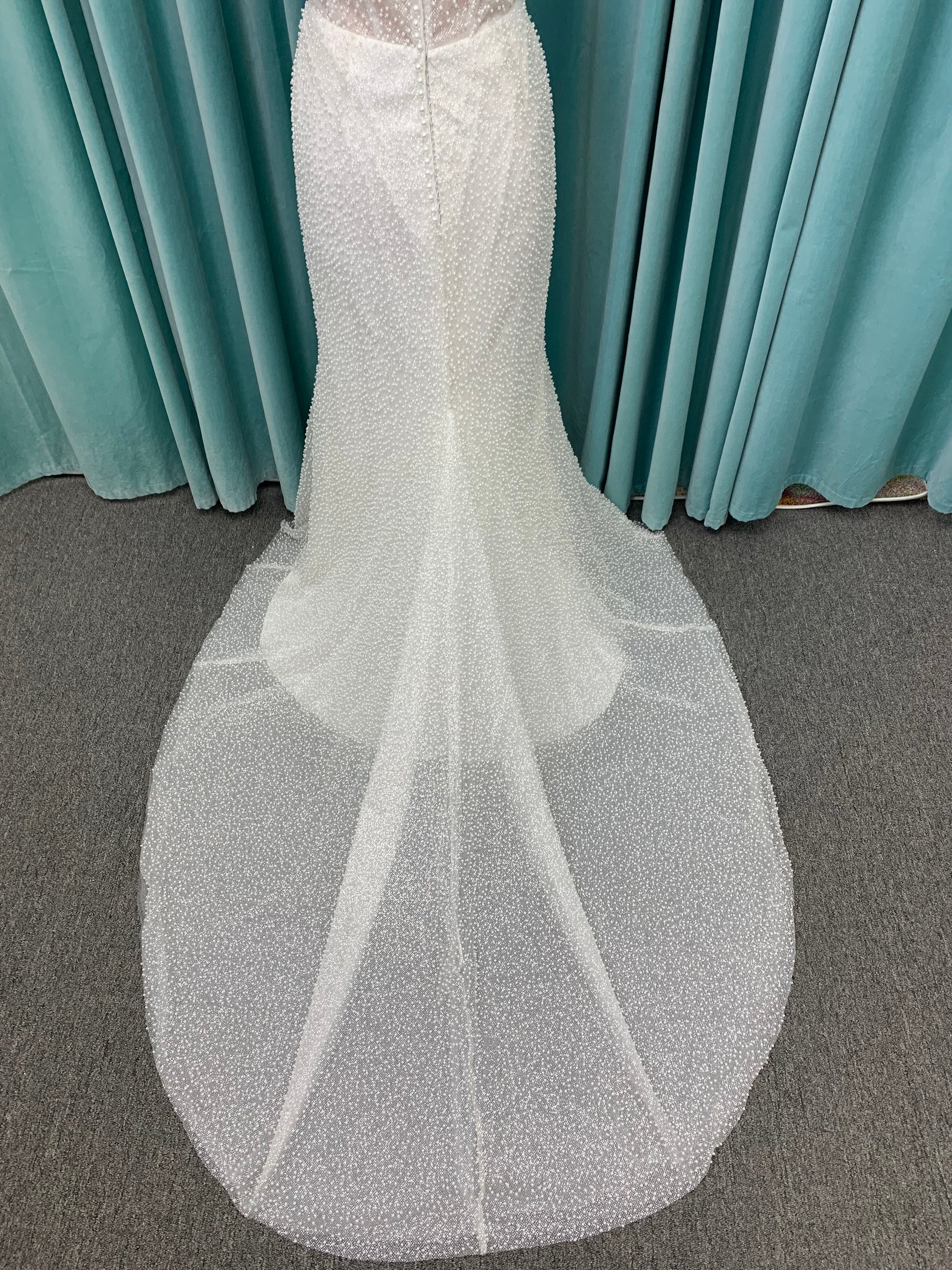 Cynthia ivory strapless fit-and-flare wedding dress on mannequin with pearl-beaded corset bodice and sweetheart neckline.

