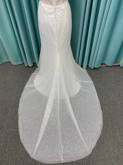 Cynthia ivory strapless fit-and-flare wedding dress on mannequin with pearl-beaded corset bodice and sweetheart neckline.
