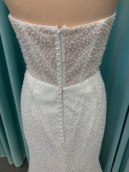 Cynthia ivory strapless fit-and-flare wedding dress on mannequin with pearl-beaded corset bodice and sweetheart neckline.
