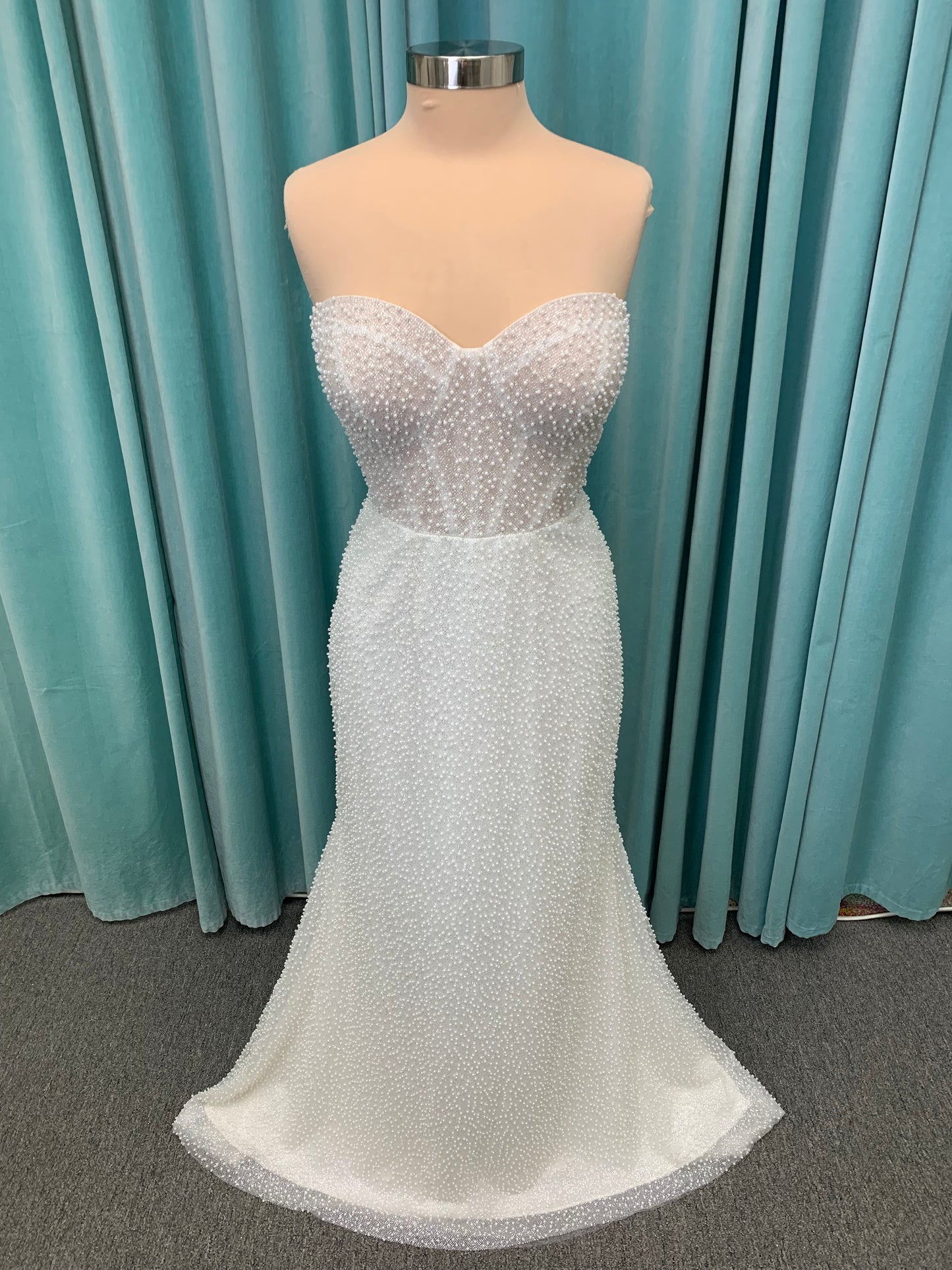 Cynthia ivory strapless fit-and-flare wedding dress on mannequin with pearl-beaded corset bodice and sweetheart neckline.
