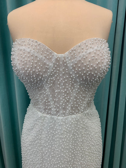 Cynthia ivory strapless fit-and-flare wedding dress on mannequin with pearl-beaded corset bodice and sweetheart neckline.
