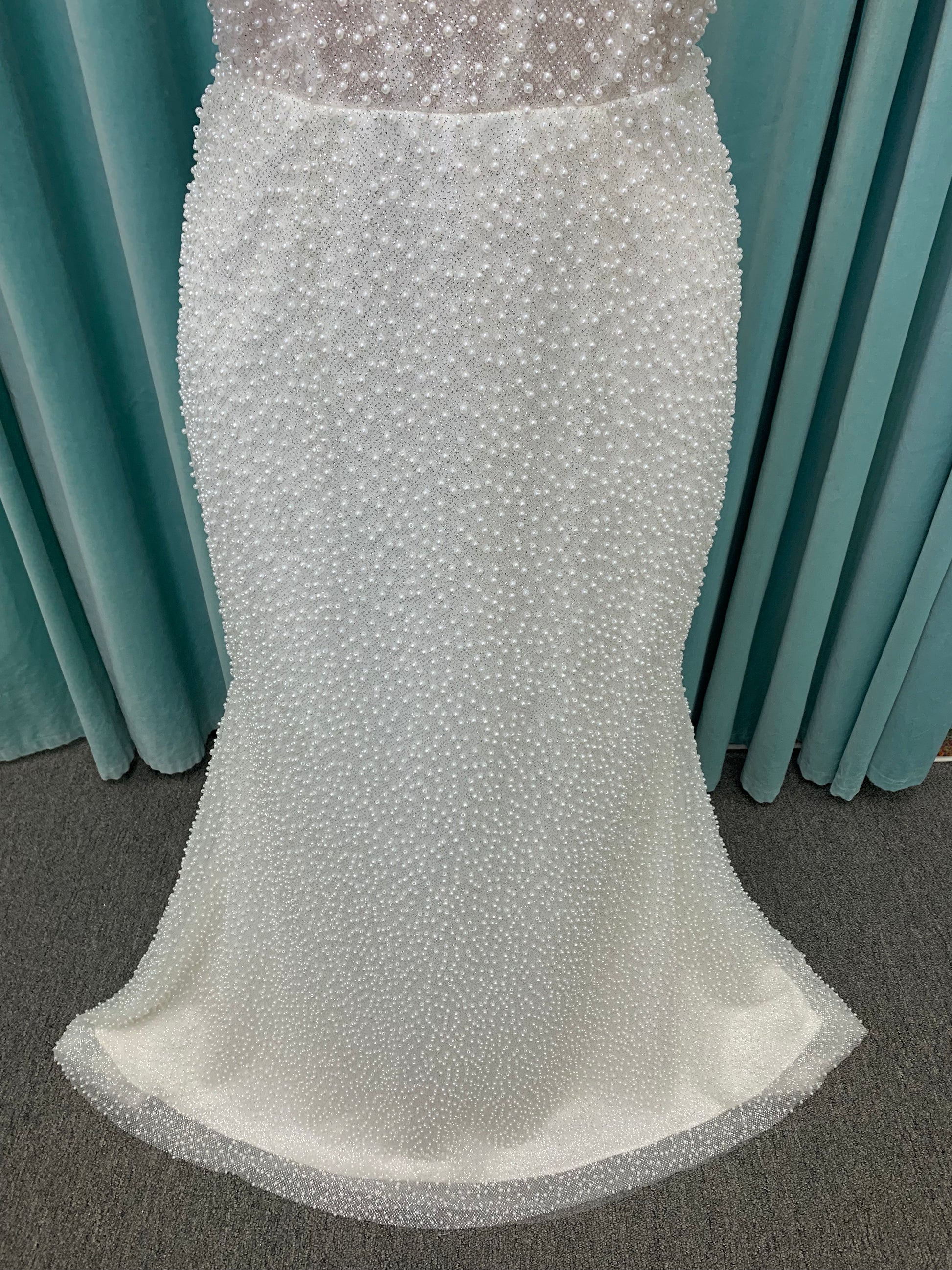 Cynthia ivory strapless fit-and-flare wedding dress on mannequin with pearl-beaded corset bodice and sweetheart neckline.
