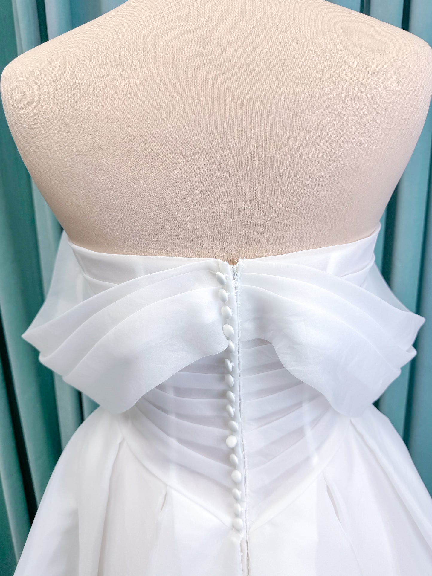 Morilee 2947L Damara A-line wedding dress on mannequin with modified sweetheart neckline, off-the-shoulder detailing, organza box pleats, and corset back