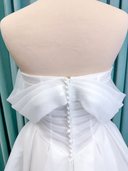 Morilee 2947L Damara A-line wedding dress on mannequin with modified sweetheart neckline, off-the-shoulder detailing, organza box pleats, and corset back