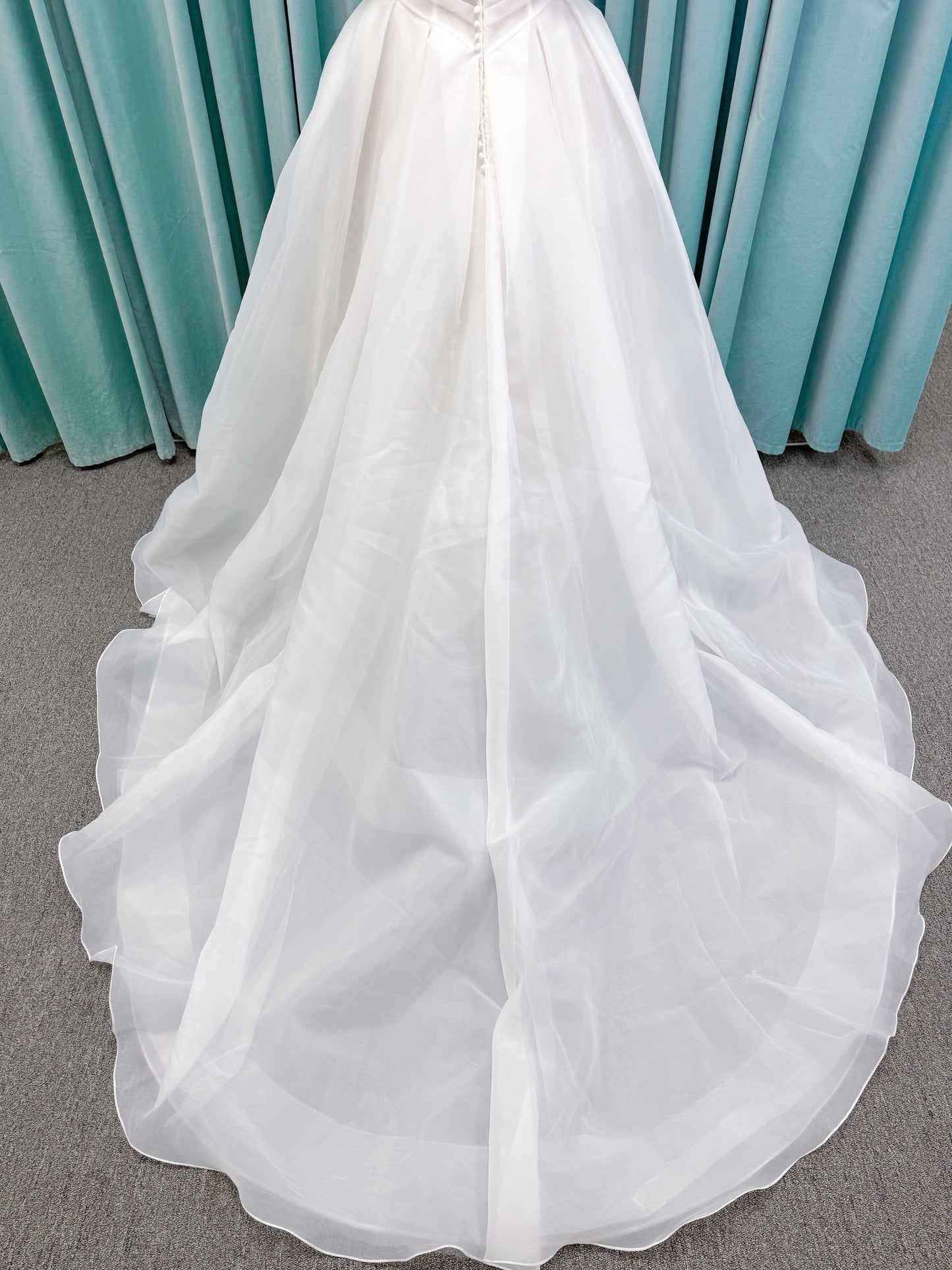 Morilee 2947L Damara A-line wedding dress on mannequin with modified sweetheart neckline, off-the-shoulder detailing, organza box pleats, and corset back