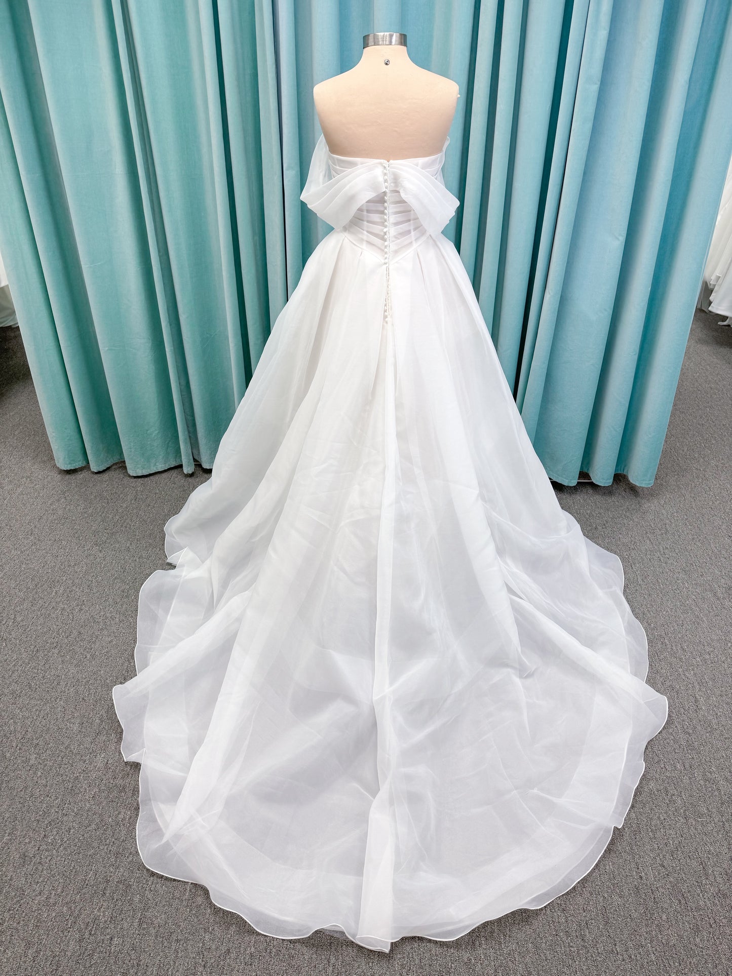 Morilee 2947L Damara A-line wedding dress on mannequin with modified sweetheart neckline, off-the-shoulder detailing, organza box pleats, and corset back