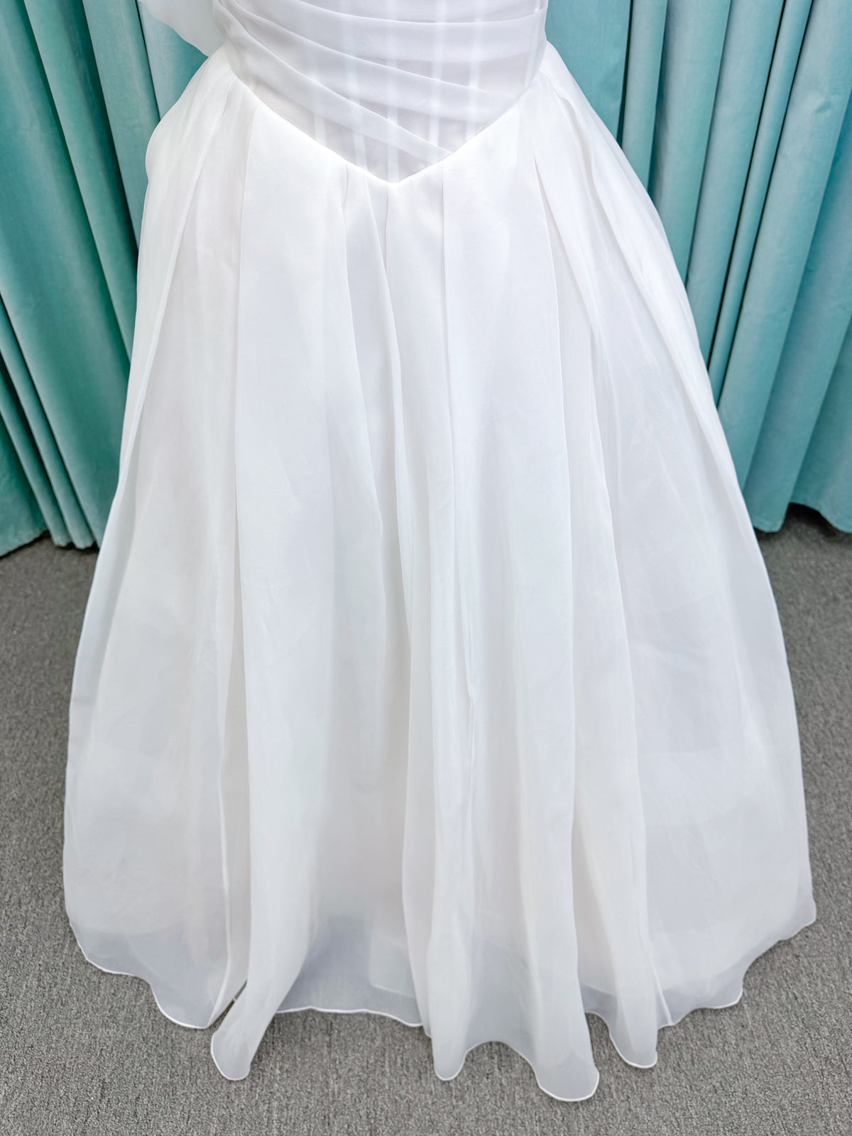 Morilee 2947L Damara A-line wedding dress on mannequin with modified sweetheart neckline, off-the-shoulder detailing, organza box pleats, and corset back