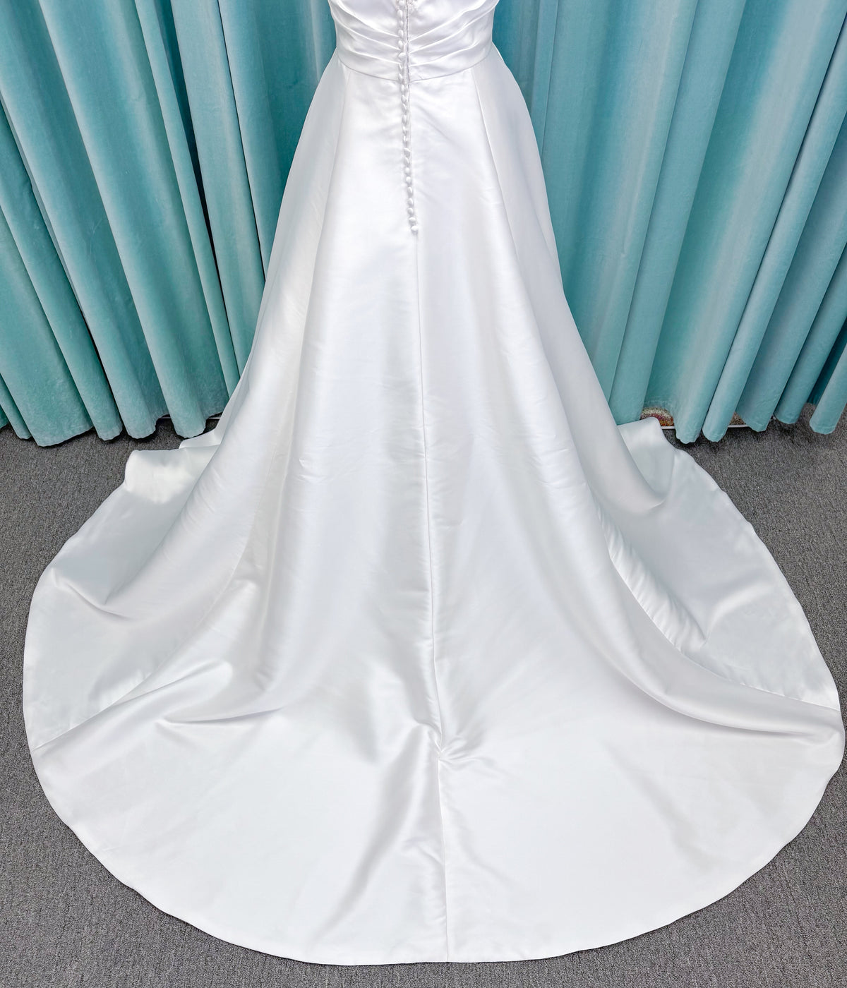 Morilee 1010001 Dove ballgown wedding dress on mannequin with strapless scoop neckline, lace peek-a-boo detail, and softly pleated skirt