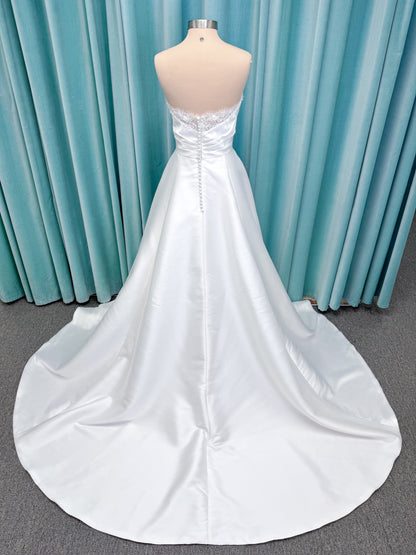 Morilee 1010001 Dove ballgown wedding dress on mannequin with strapless scoop neckline, lace peek-a-boo detail, and softly pleated skirt