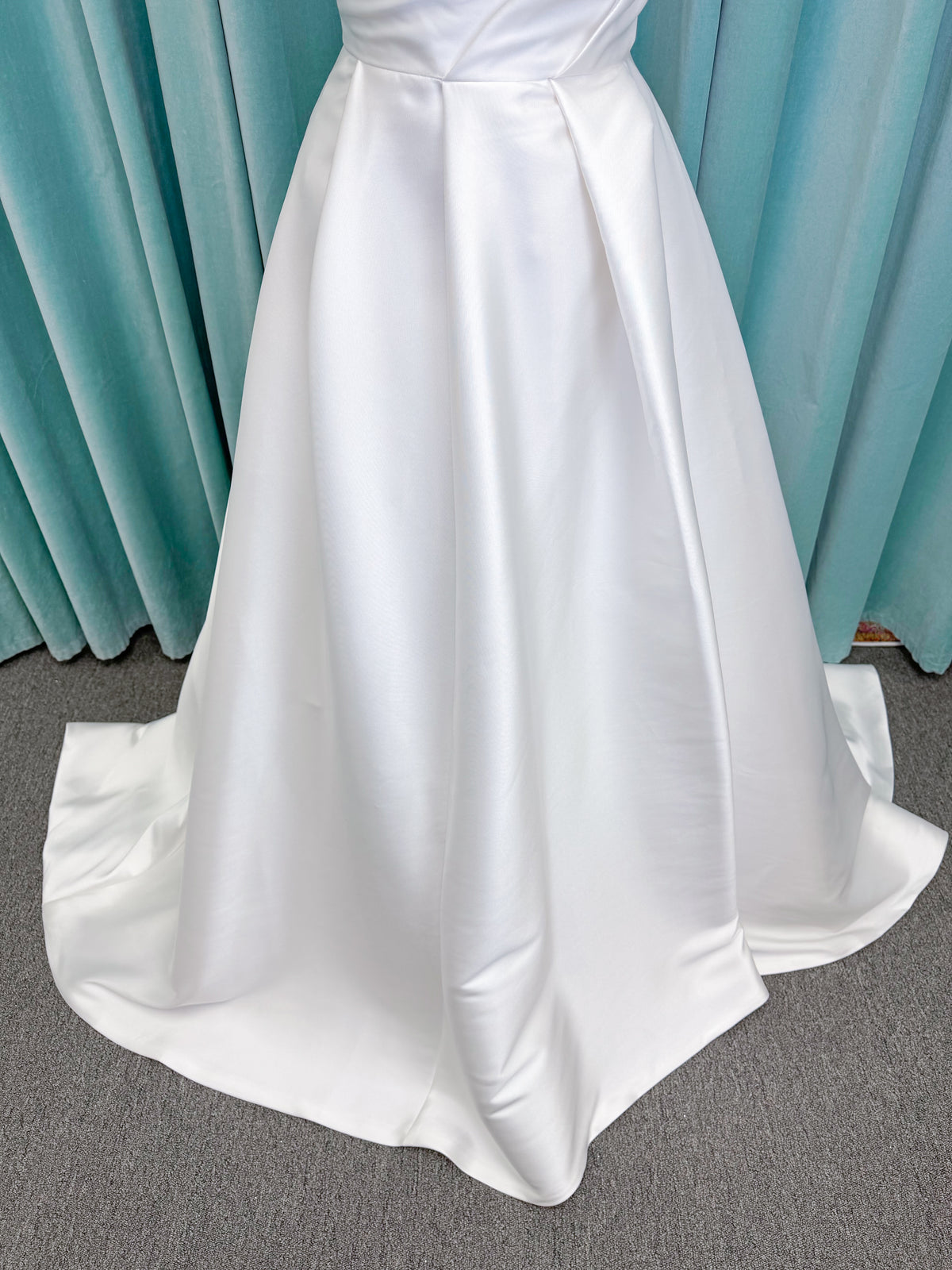 Morilee 1010001 Dove ballgown wedding dress on mannequin with strapless scoop neckline, lace peek-a-boo detail, and softly pleated skirt