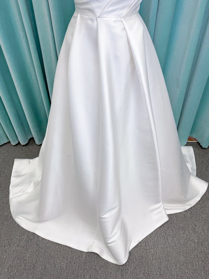 Morilee 1010001 Dove ballgown wedding dress on mannequin with strapless scoop neckline, lace peek-a-boo detail, and softly pleated skirt