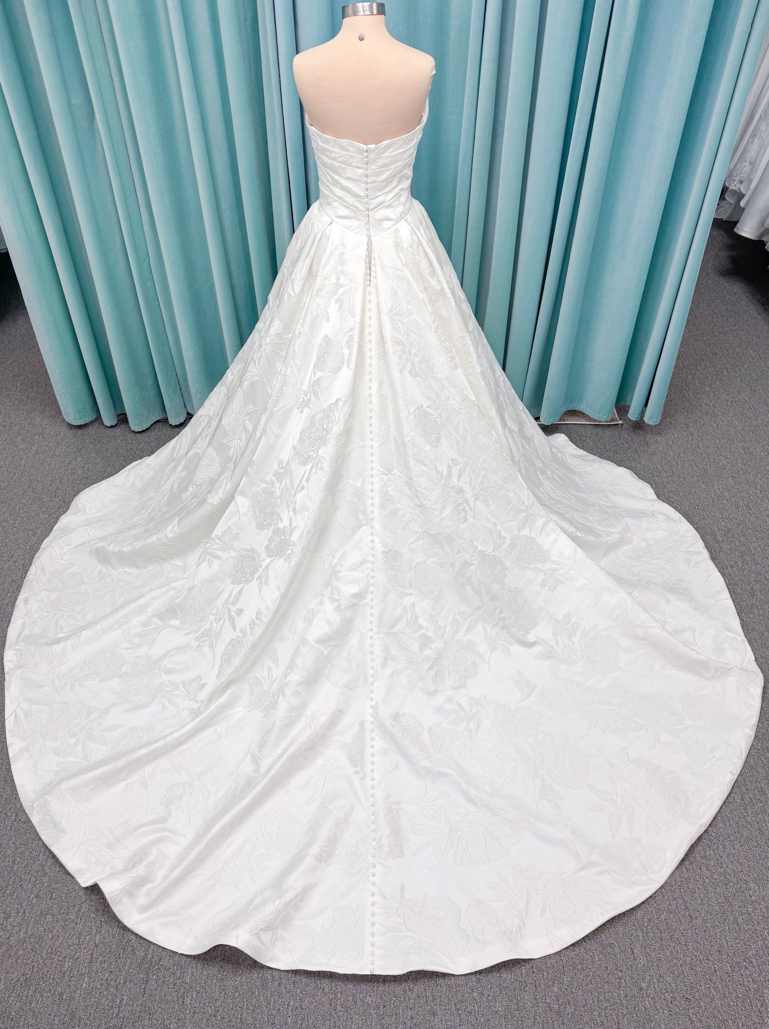 Strapless floral jacquard ballgown wedding dress with a sweetheart neckline, ruched bodice, defined waist, and full structured skirt.