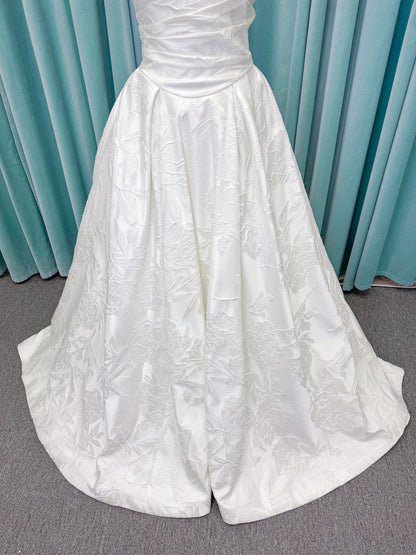 Strapless floral jacquard ballgown wedding dress with a sweetheart neckline, ruched bodice, defined waist, and full structured skirt.