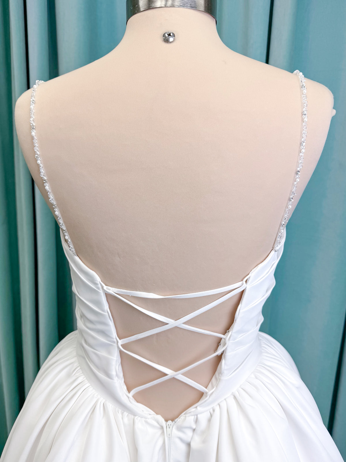 Morilee 1010003 Eleve A-line wedding dress on mannequin with scoop neckline, Chantilly lace peek-a-boo detail, beaded straps, and lace-up corset back