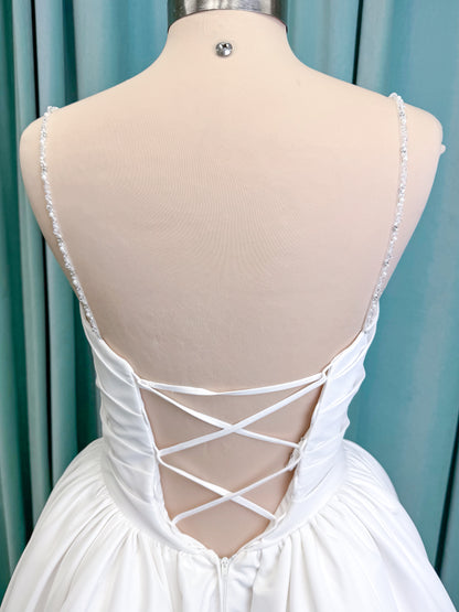 Morilee 1010003 Eleve A-line wedding dress on mannequin with scoop neckline, Chantilly lace peek-a-boo detail, beaded straps, and lace-up corset back