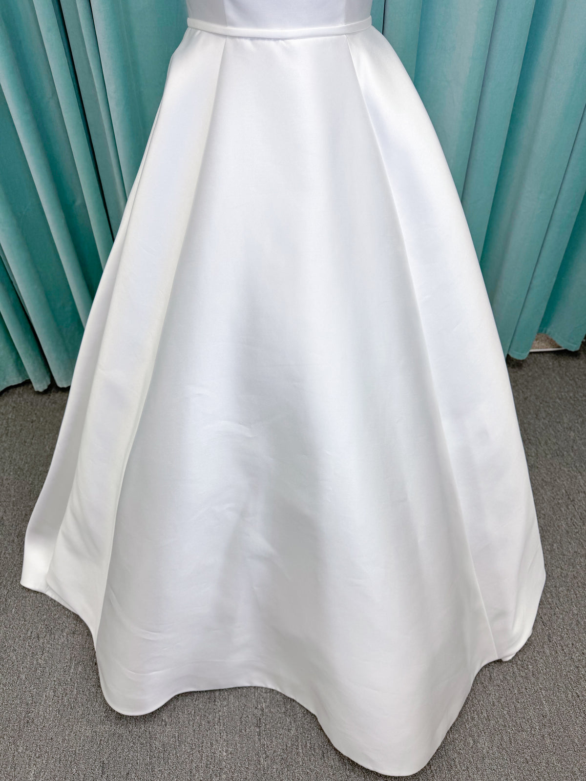 Morilee 2996 Eowyn A-line wedding dress on mannequin with square neckline, slender straps, Mikado fabric, and pockets