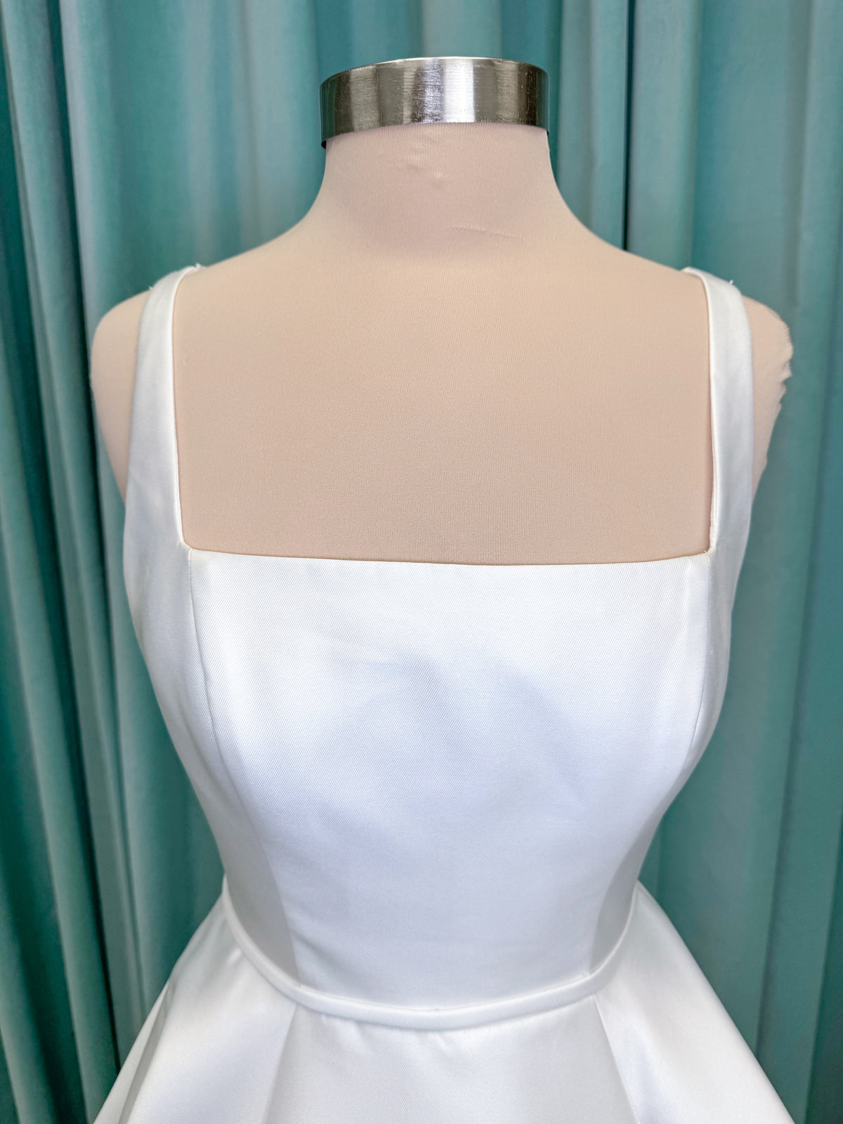 Morilee 2996 Eowyn A-line wedding dress on mannequin with square neckline, slender straps, Mikado fabric, and pockets