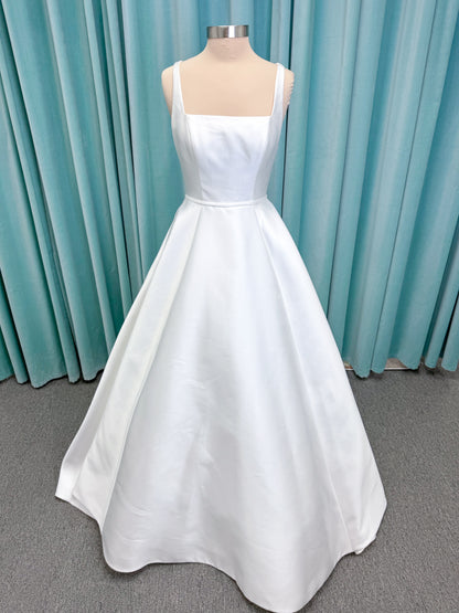 Morilee 2996 Eowyn A-line wedding dress on mannequin with square neckline, slender straps, Mikado fabric, and pockets