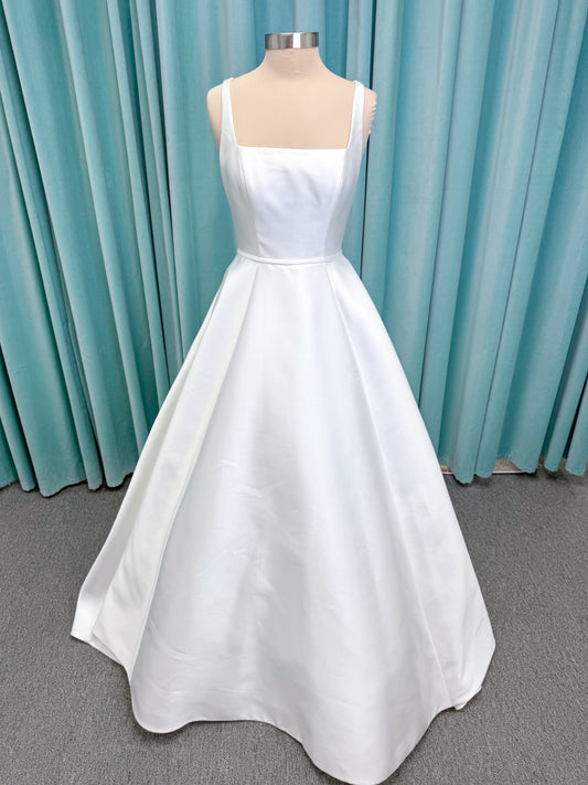 Morilee 2996 Eowyn A-line wedding dress on mannequin with square neckline, slender straps, Mikado fabric, and pockets