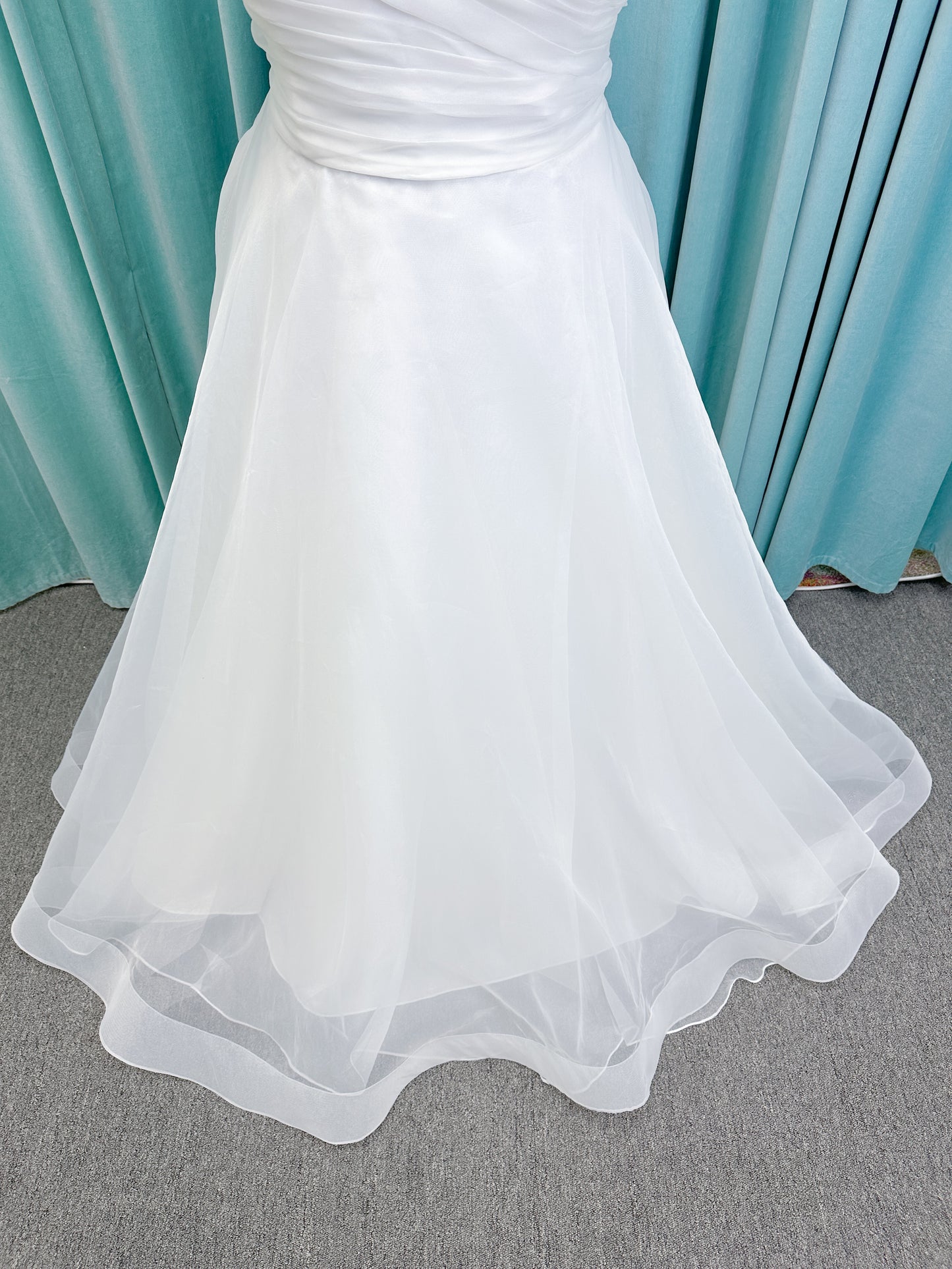 Morilee 3350 Evette ball gown wedding dress in draped organza with off-the-shoulder surplice bodice, horsehair-edged skirt, and covered buttons to hem.