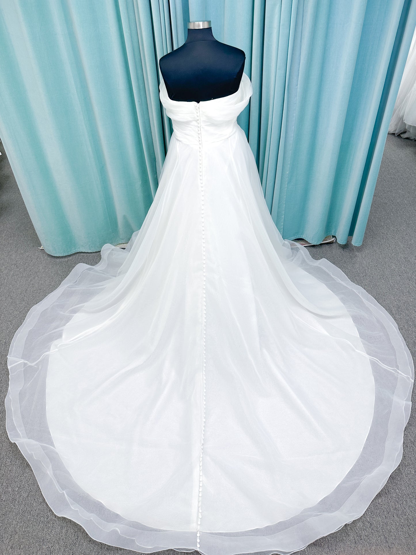Morilee 3350 Evette ball gown wedding dress in draped organza with off-the-shoulder surplice bodice, horsehair-edged skirt, and covered buttons to hem.
