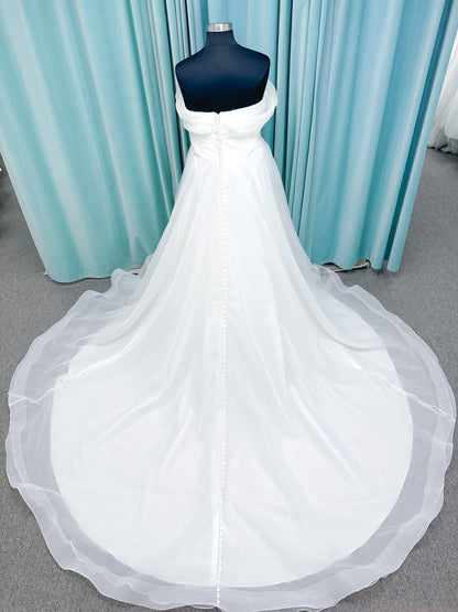 Morilee 3350 Evette ball gown wedding dress in draped organza with off-the-shoulder surplice bodice, horsehair-edged skirt, and covered buttons to hem.