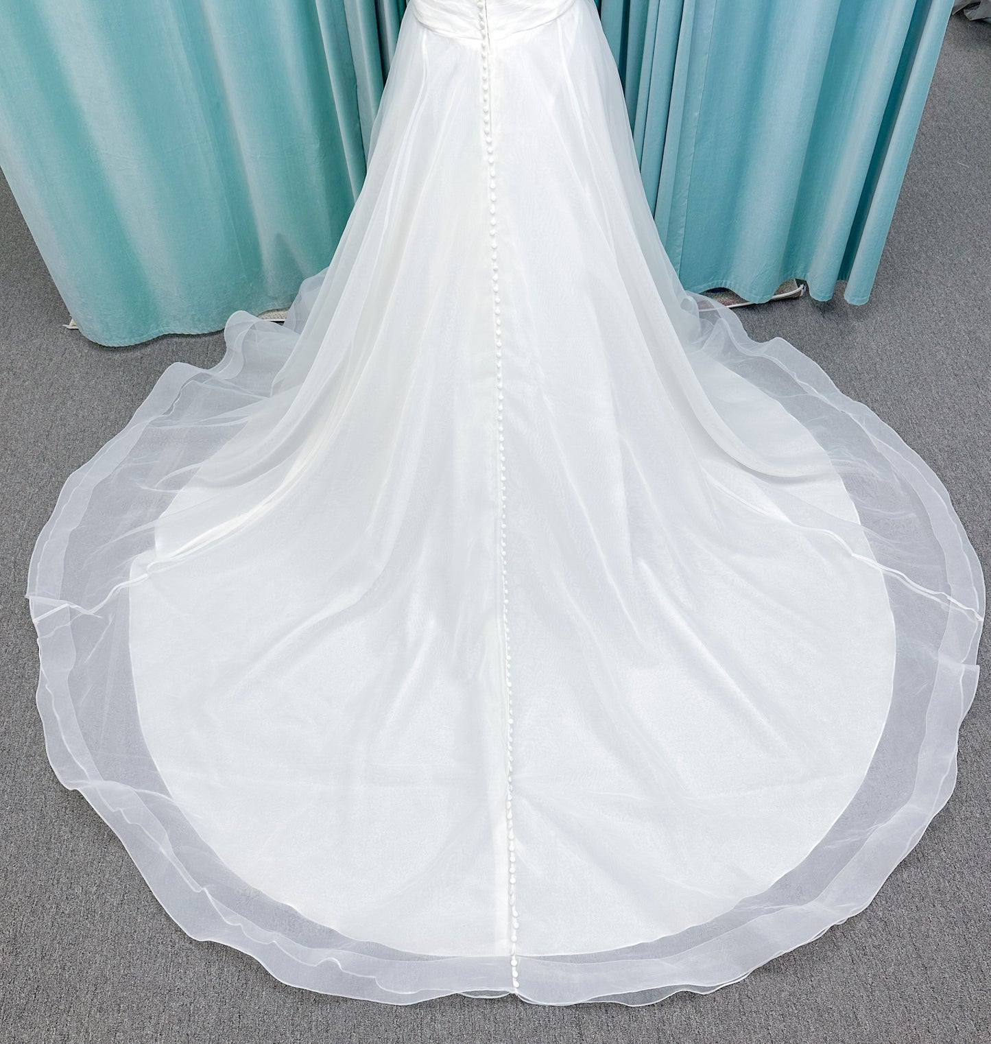 Morilee 3350 Evette ball gown wedding dress in draped organza with off-the-shoulder surplice bodice, horsehair-edged skirt, and covered buttons to hem.