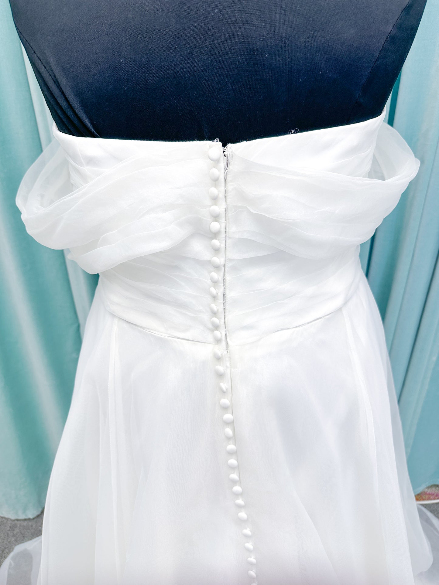 Morilee 3350 Evette ball gown wedding dress in draped organza with off-the-shoulder surplice bodice, horsehair-edged skirt, and covered buttons to hem.