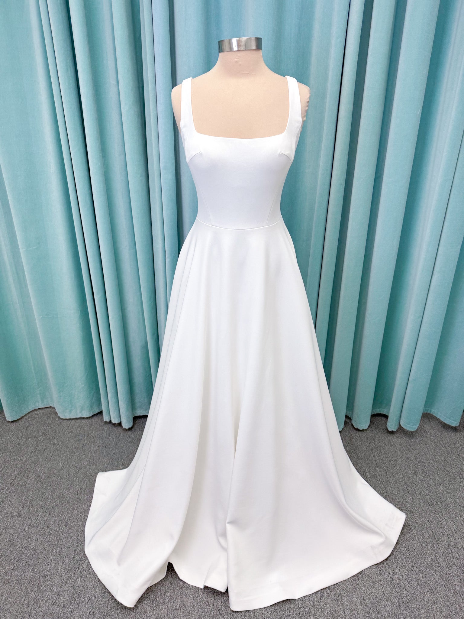 A-Line Ivory wedding dress on mannequin with square neckline and matte crepe A-line skirt